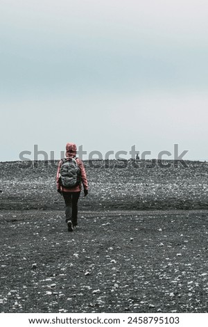 Lonely tourist on a beach. Photographer walks on the sand. Inspiration, freedom, travel, photography. Northern lands, cold, windbreaker.