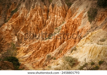 Red clay quarry in Portugal. Red clay waves background. Selective focus. 