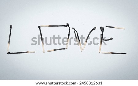 Love - an expression arranged from burnt matches on a white background. Concept.