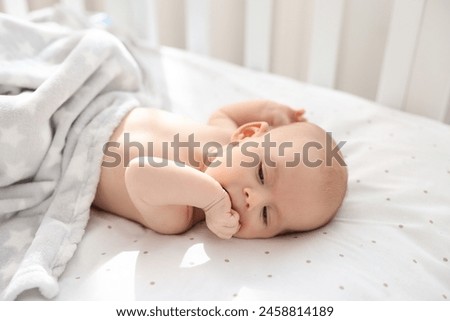 Cute little baby lying in crib at home Royalty-Free Stock Photo #2458814189