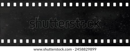Long strip of old and dirty celluloid film with dust and scratches isolated on background Royalty-Free Stock Photo #2458829899