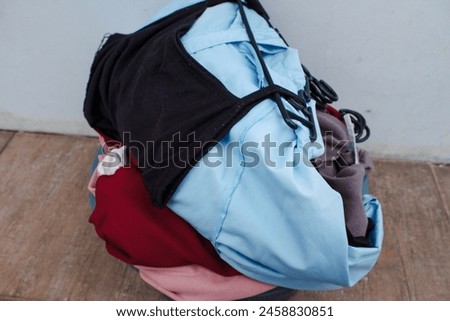 Clothes in a laundry wooden basket on floor, stock photo. 
