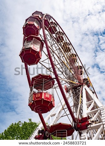 A large Ferris Wheel against a cloudy sky Royalty-Free Stock Photo #2458833721