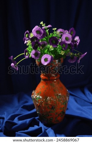 Still life photography with Colorful flowers on old wooden table. The table is covered with a cloth