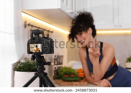 Food blogger explaining something while recording video in kitchen, focus on camera Royalty-Free Stock Photo #2458873031
