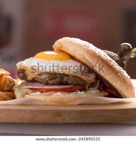 Hamburger with egg and potatoes on the table