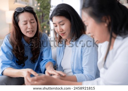 Asian woman friend group mature women meeting and sharing personal stories laughing at home while drinking coffee woman energetic women meeting and sharing personal stories in a living room warm house Royalty-Free Stock Photo #2458921815