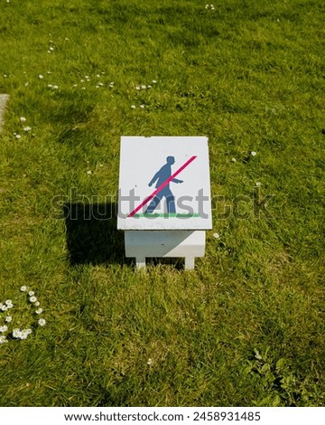 No walking on grass sign in a sunny park, promoting environmental protection and related to Earth Day and outdoor regulations