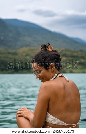 Woman looking to the side with a bikini on a lake