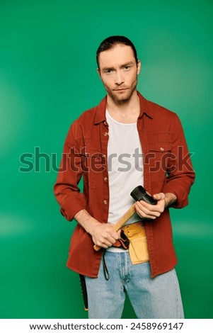 Handsome man in work uniform with camera on green backdrop.