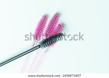 Top view of a Composition of four mascara applicators. Three pink and one black