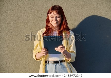 Young female college student using digital tablet outdoor