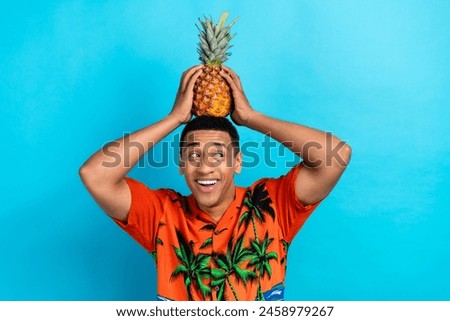 Photo of funky dreamy guy dressed print shirt holding head pineapple looking emtpy space isolated blue color background