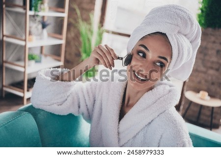 Photo portrait of lovely young lady apply roller massager face wrapped towel dressed bath robe beauty treatment personal care home concept