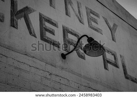 An old industrial light on the side of a vintage ice house. Royalty-Free Stock Photo #2458983403