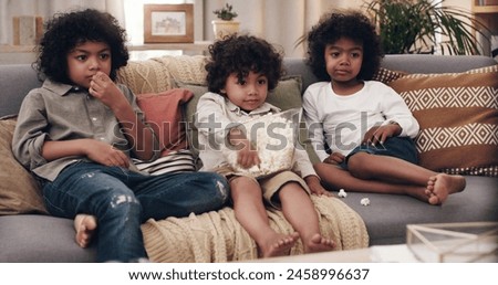 Eating popcorn, couch and children in living room for bonding, cartoons and entertainment in school holidays. Brothers, together and snacking on sofa for quality time, tv shows and relaxing at home