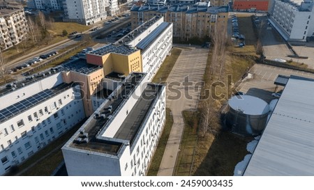 Drone photography of multistory houses, streets and sidewalks in a city during spring sunny day