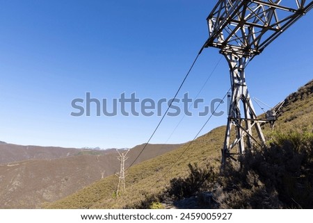 Abandoned industrial coal mining steel structure tower from cableway with cable in Tormaleo Asturias province of Spain on a bright sunny day. Royalty-Free Stock Photo #2459005927