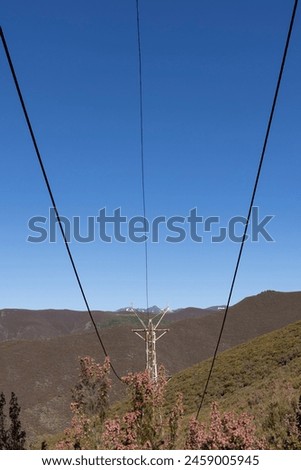 Abandoned industrial coal mining steel structure tower from cableway with cable in Tormaleo Asturias province of Spain on a bright sunny day. Royalty-Free Stock Photo #2459005945