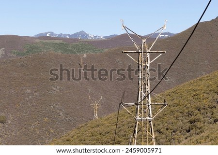 Abandoned industrial coal mining steel structure tower from cableway with cable in Tormaleo Asturias province of Spain on a bright sunny day. Royalty-Free Stock Photo #2459005971