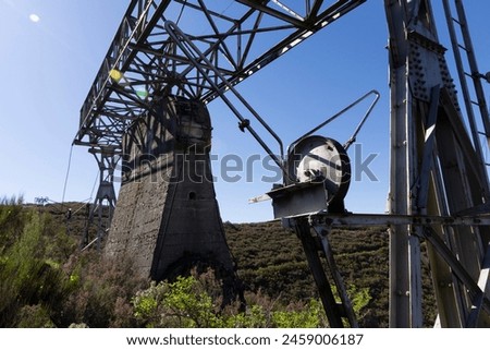 Metal structure tower with concrete base from coal mine cable cart industrial abandoned cableway on a spring sunny day in Tormaleo province of Asturias Spain Royalty-Free Stock Photo #2459006187