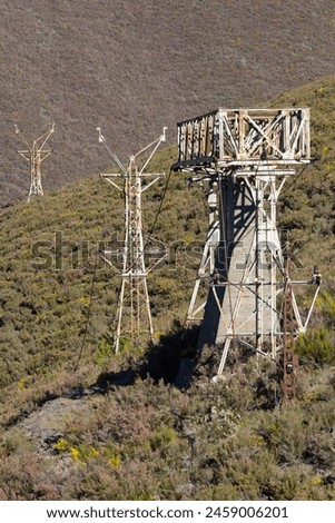 Abandoned steel structure with towers from industrial coal mining cableway in mountains of Asturias Spain in Tormaleo on a sunny spring day with flowers Royalty-Free Stock Photo #2459006201