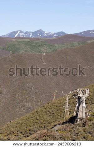 Abandoned steel structure with towers from industrial coal mining cableway in mountains of Asturias Spain in Tormaleo on a sunny spring day with flowers Royalty-Free Stock Photo #2459006213