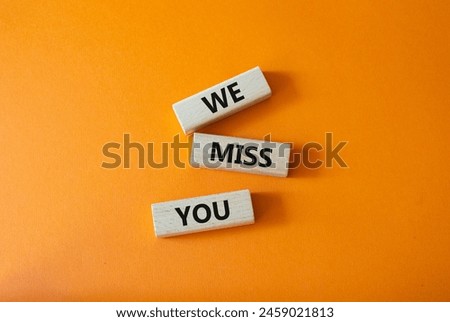 We Miss you symbol. Concept words We Miss you on wooden blocks. Beautiful orange background. Emotion and We Miss you concept. Copy space.