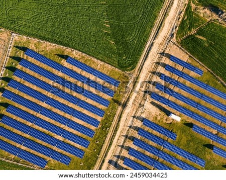 Sunset Glow of Green Energy: 4K UHD image of Solar Panel Power Plant in Beautiful Green Fields - Renewable Energy Background