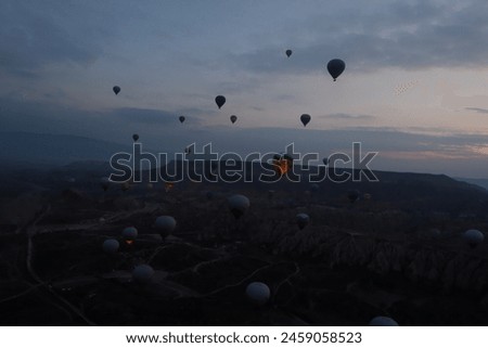 Feel the freezing while waiting for sunrise in hot balloons before dawn to drive out to scenic viewpoints, and colorful ball gowns, and snap photos with fairy chimneys in the winter Cappadocia, Turkey Royalty-Free Stock Photo #2459058523