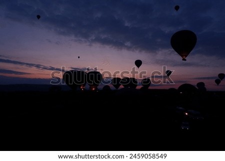 Feel the freezing while waiting for sunrise in hot balloons before dawn to drive out to scenic viewpoints, and colorful ball gowns, and snap photos with fairy chimneys in the winter Cappadocia, Turkey Royalty-Free Stock Photo #2459058549