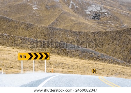 Road through Lindis Pass Alpine Highway,  New Zealand - speed sign of 55km for approaching the corner. 