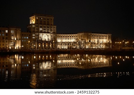 night view of the city and still with dry grass, reflection of lights in the water, beautiful and bright, night city and nature