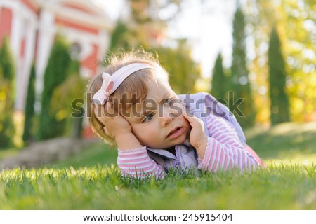scared girl laying on grass in sunlight