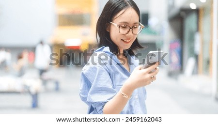 Urban business people lifestyles concept. Young adult asian woman using smartphone. Joy and Positive look enhance self love. Background in city. Casual trend fashion with shirt.
