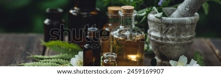 Herbal essential oil in old vintage apothecary glass bottles. Alternative medicine, skin care, aromatherapy and natural organic ingredients for medicine, pharmacy, fragrance cosmetic production banner Royalty-Free Stock Photo #2459169907