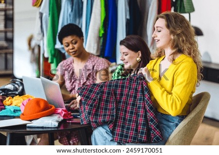 Group of young women creating small modern business start up, project for fashion design, clothes creation. Concept of people at work, purchasing and online shopping. Friends learning, college life