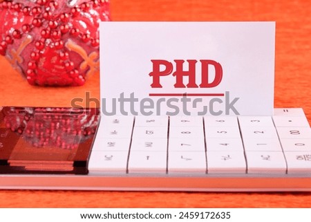 Word PhD. Doctor of Philosophy. PHD on a white business card with a calculator