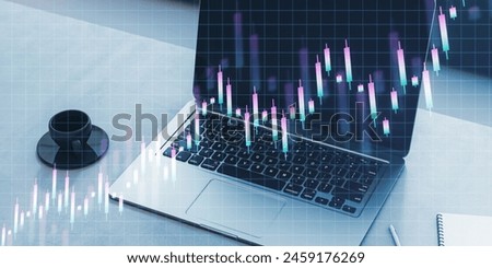 Close up of laptop on desk with coffee cup and creative growing candlestick forex chart on blue grid background. Financial growth and stock concept. Double exposure