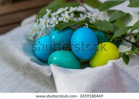 A basket brimming with uniquely colored Easter eggs in shades of blue and green, evoking a sense of mystery and wonder.