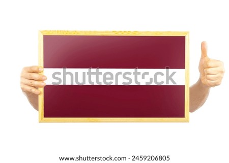 Hands holding a frame with Latvia flag, approvement or success in Latvia, two hands and thumb up, celebration or victory concept, independence day idea