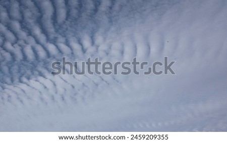 A group of cirrostratus clouds against a blue sky. Royalty-Free Stock Photo #2459209355