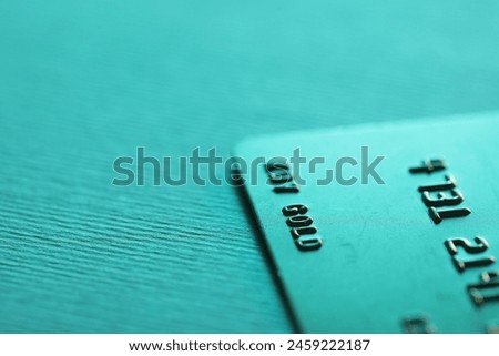 One credit card on turquoise background, closeup. Space for text Royalty-Free Stock Photo #2459222187
