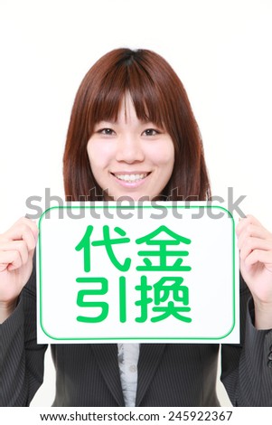 businesswoman holding a message board with the phrase cash on delivery in KANJI