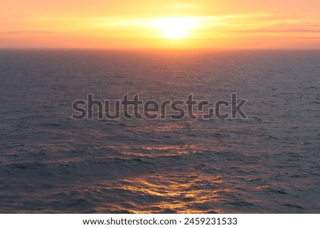 Dawn at sea, with waves tinged with golden sunlight Royalty-Free Stock Photo #2459231533