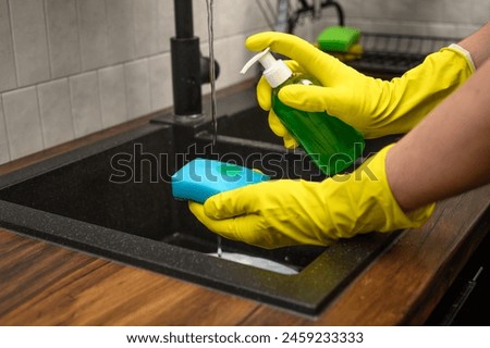 Close-up of dishwashing liquid dispensed onto a kitchen sponge
