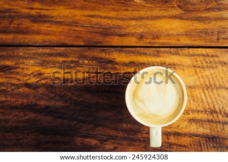 Hot latte cup on wooden background - vintage effect style pictures