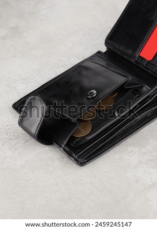 a black wallet with a red card on a gray table