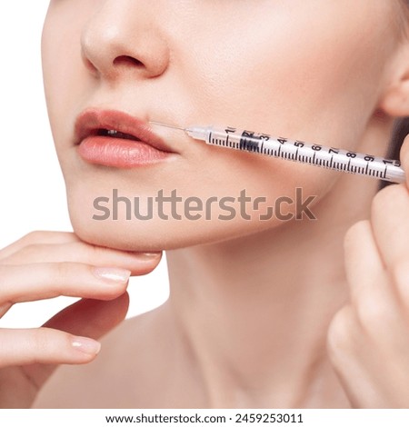 Young woman gets cosmetic injection in lips. Royalty-Free Stock Photo #2459253011