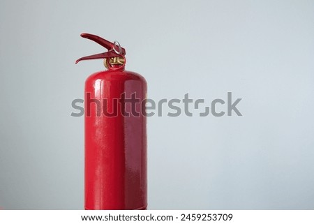 Fire extinguisher on gray background, close-up photo.